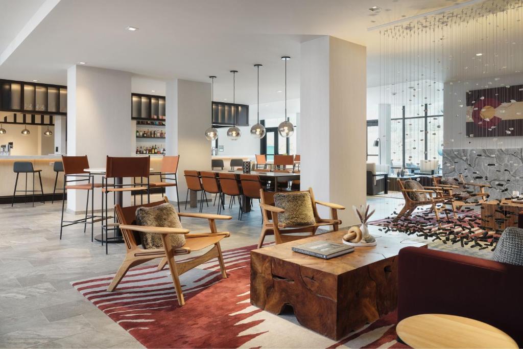 un hall avec des chaises et des tables ainsi qu'un bar dans l'établissement AC Hotel by Marriott Frisco Colorado, à Frisco