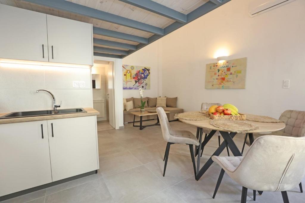 - une cuisine et une salle à manger avec une table et des chaises dans l'établissement Modern Loft Syros, à Áno Sýros