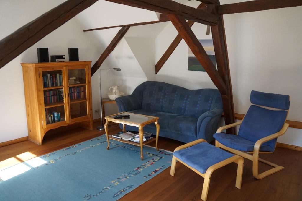a living room with a blue couch and two chairs at Gästehaus Sehl in Senheim