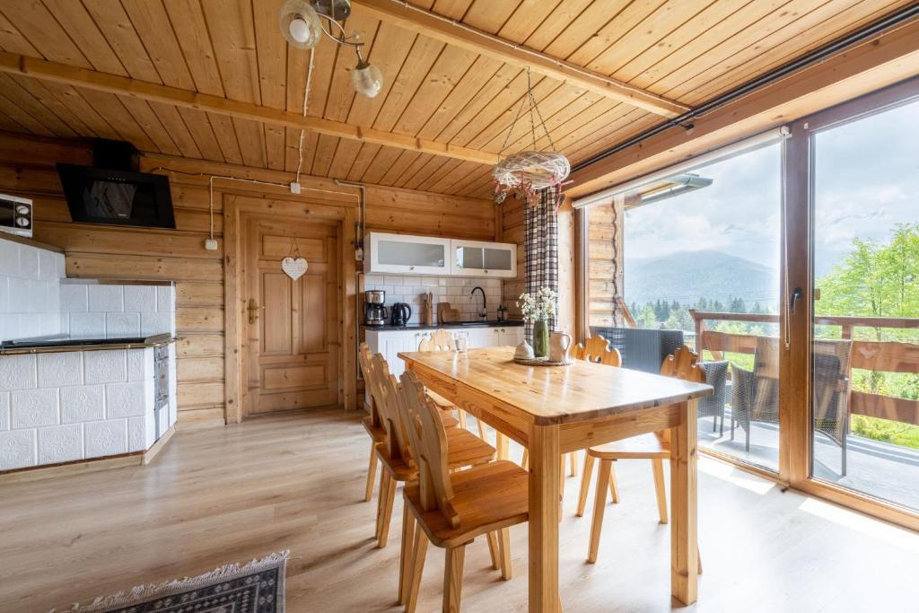 a kitchen and dining room with a wooden table and chairs at Domek Hacienda in Kościelisko