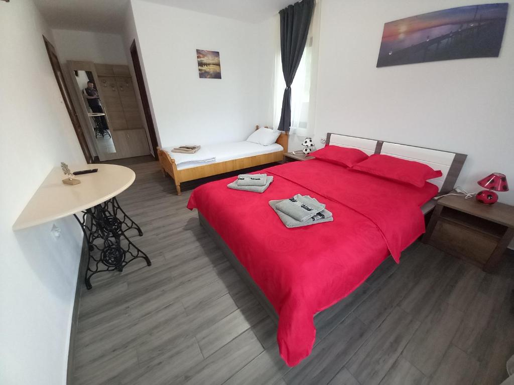 Un dormitorio con una gran cama roja con almohadas rojas en Cabana BRO Clisura Dunarii en Liborajdea