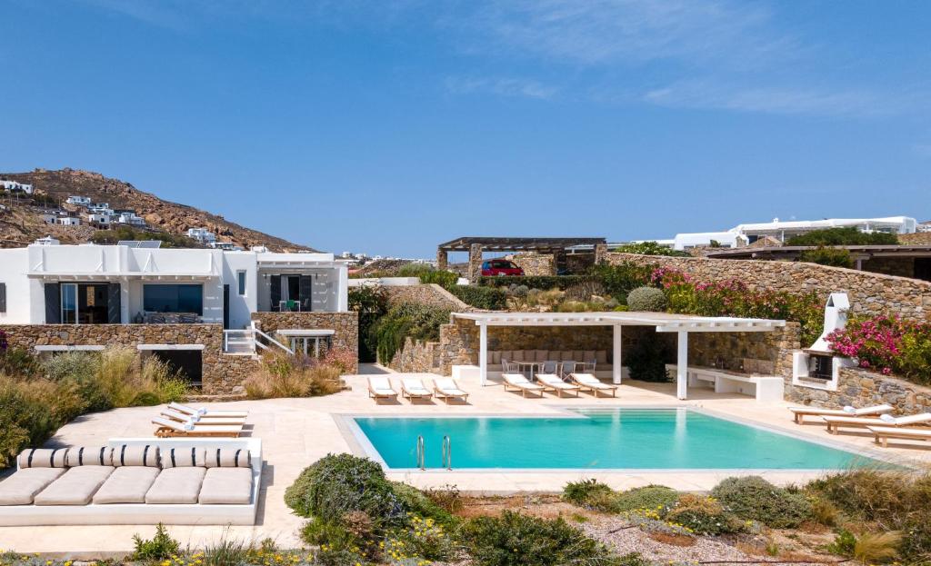 a villa with a swimming pool and lounge chairs at Villa Etcetera in Elia Beach