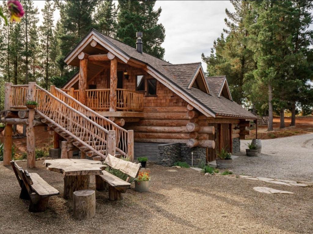 a log cabin with a picnic table and a porch at Magical Loft - Homewood Forest Retreat in Alexandra