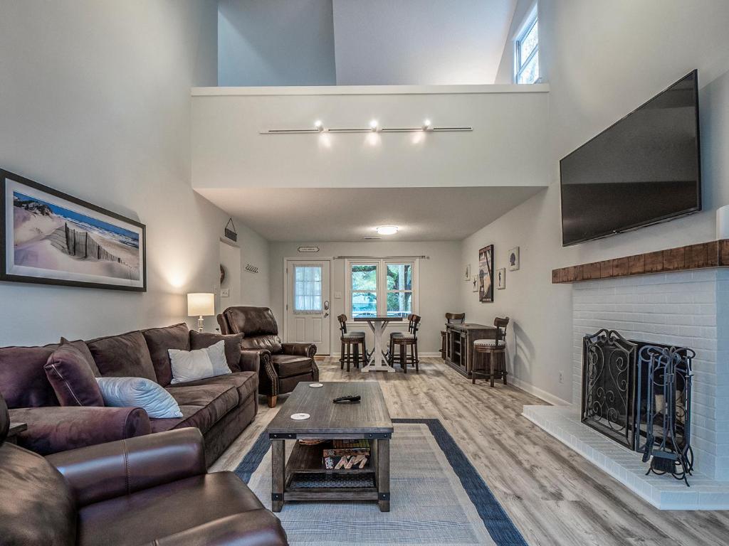 a living room with a couch and a fireplace at 545 Tarpon Pond Cottage in Seabrook Island