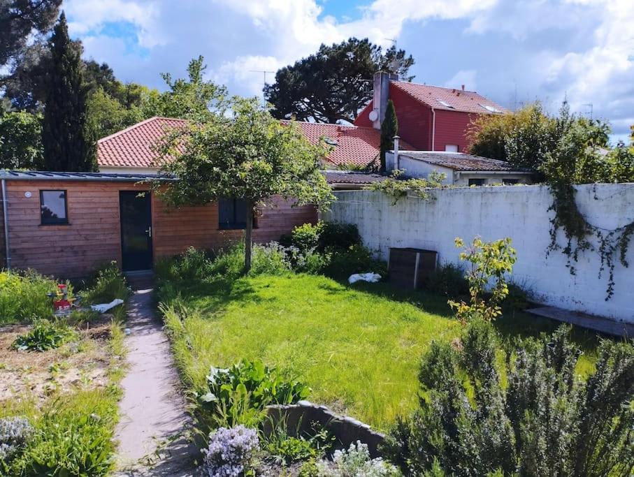 un jardin avec une maison et une clôture dans l'établissement Chambre indépendante avec SDB sur jardin, au calme, à Nantes