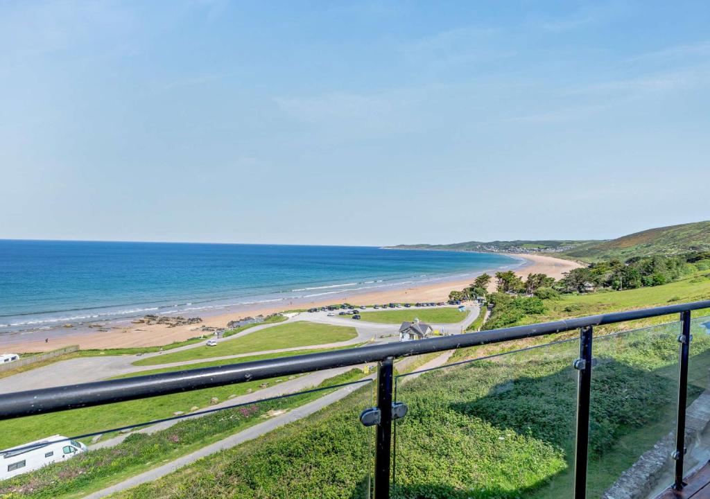 a view of a beach and the ocean from a balcony at Flat 9 Clifton Court in Croyde