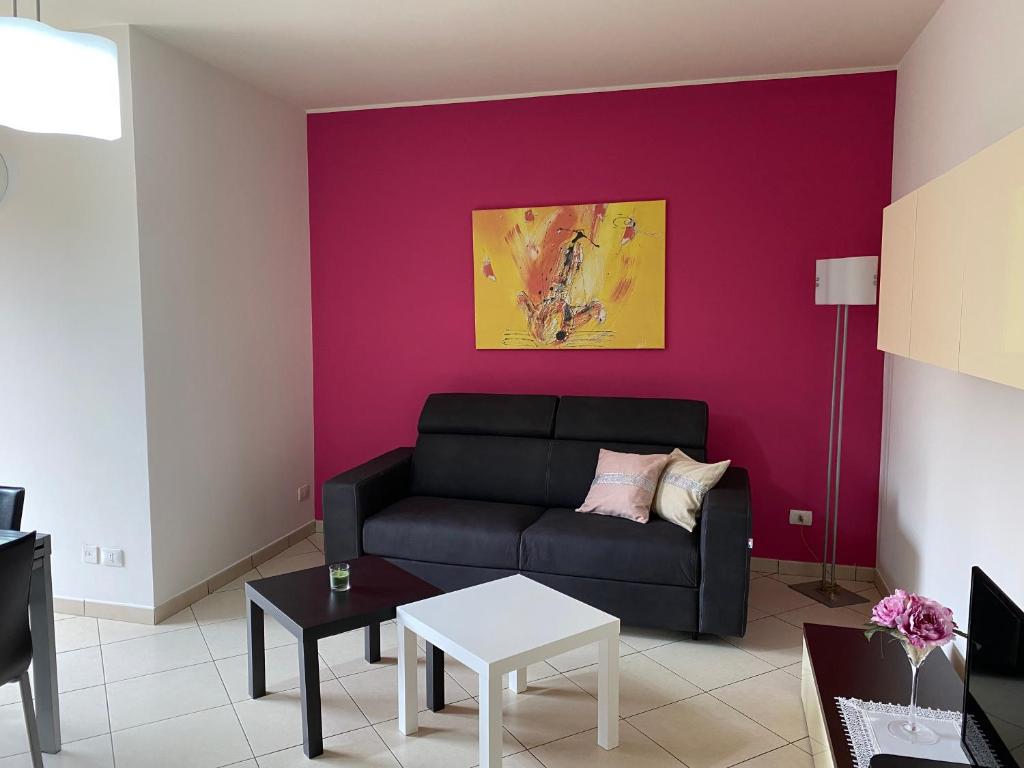 a living room with a black couch and a purple wall at CASA VACANZA DAMAR in Mascali