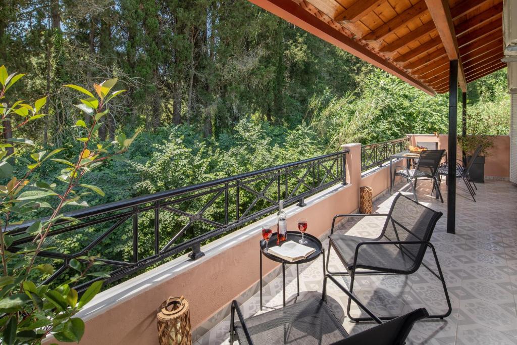 patio z krzesłami i stołem na balkonie w obiekcie Villa Apanemo w mieście Potamós