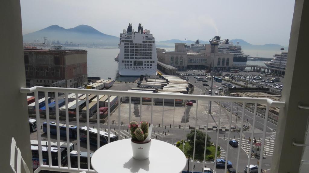 einen Balkon mit Stadtblick und einer Vase auf dem Tisch in der Unterkunft Skyhouse Beverello in Neapel