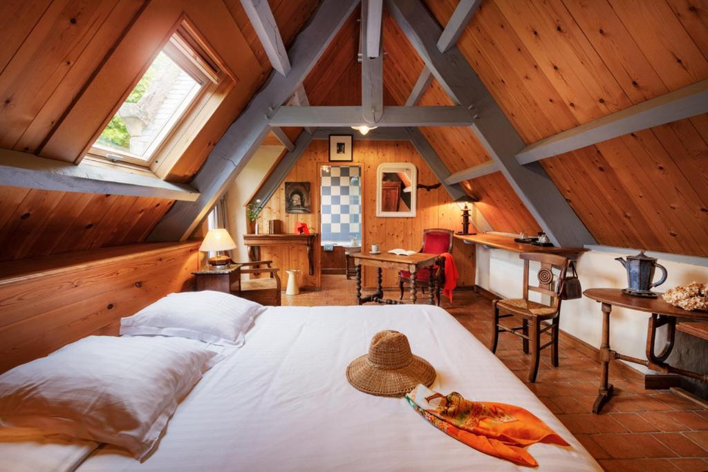 a bedroom with a large bed in a attic at La Grange de Coatélan in Plougonven