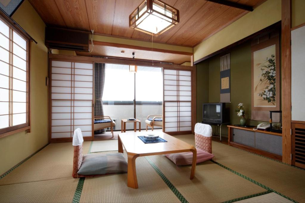 a living room with a table and a tv at Kofukan - Vacation STAY 64890v in Myoko