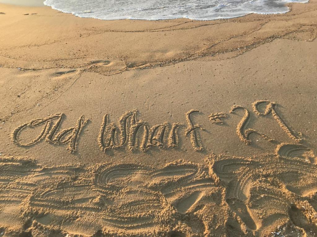 una palabra escrita en la arena en una playa en Ocean Block Condo 100 Steps From the Beach en Ocean City