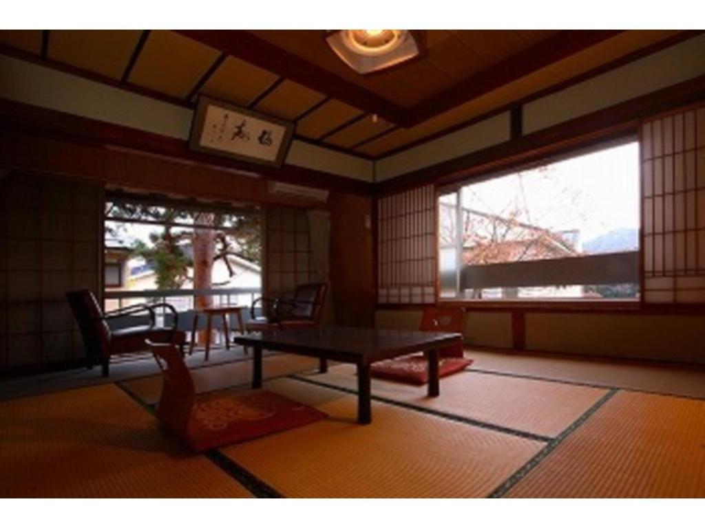 una camera con tavolo, sedie e finestre di Kofukan - Vacation STAY 67959v a Myoko