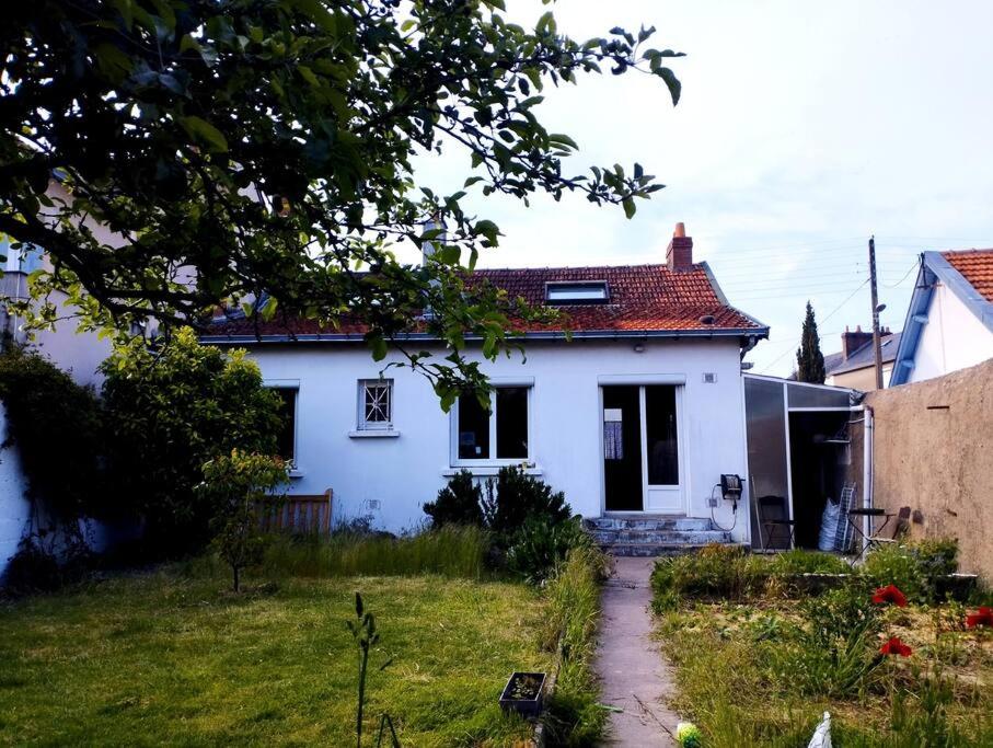 Uma casa branca com um caminho à frente. em Maison avec jardin au calme em Nantes