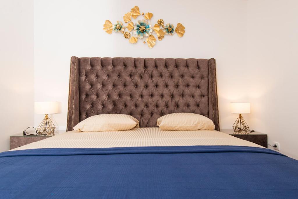 a large bed with a large headboard and two lamps at Sea star Apartment in Tivat