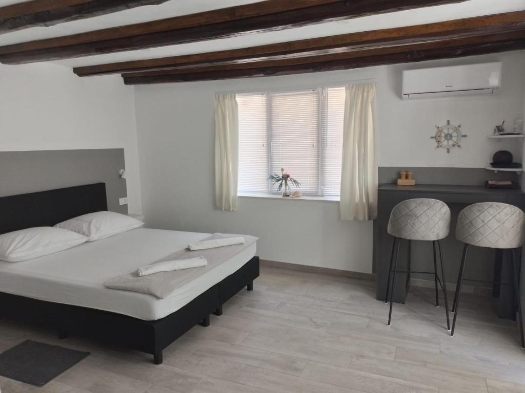 een slaapkamer met een bed, een bureau en een raam bij Apartments Ciao Bella city centre with free parking in Šibenik