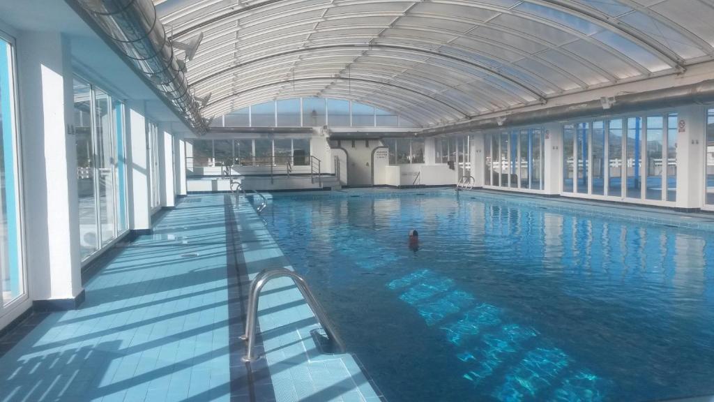 a large indoor swimming pool with a person in it at Apartamento en urbanización lujo in Tavernes de Valldigna