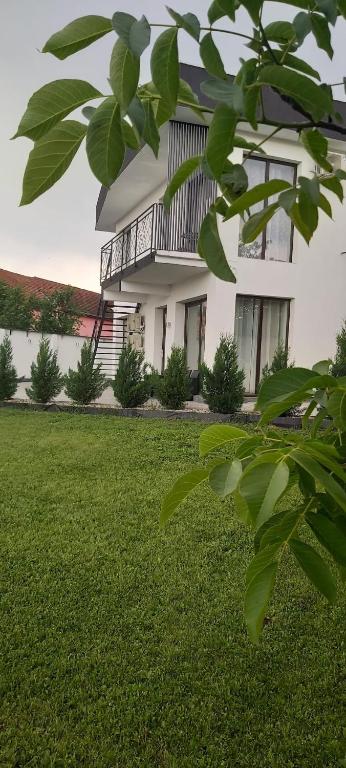 a white house with a balcony on a lawn at Accent Garden in Deva
