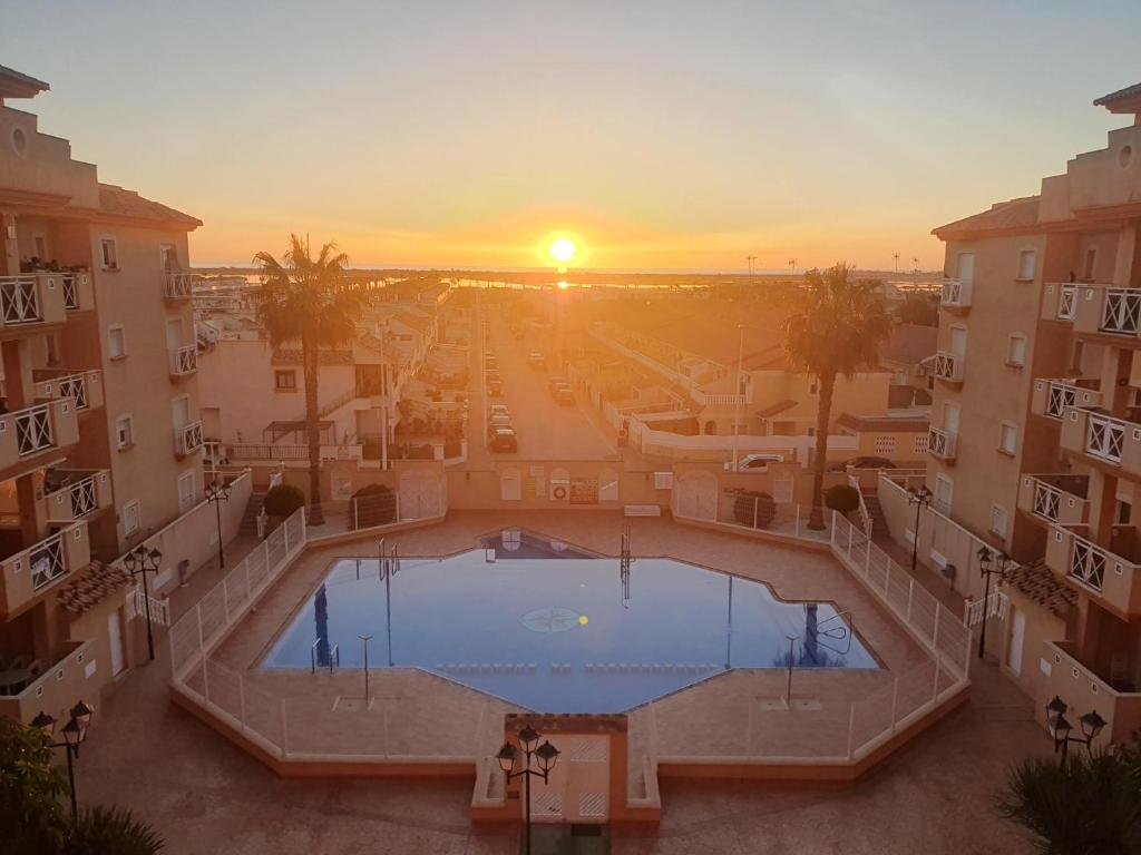 vista sulla piscina in un edificio con tramonto di Luz de sal. Alojamiento, recreo, naturaleza y más! a Lo Pagán