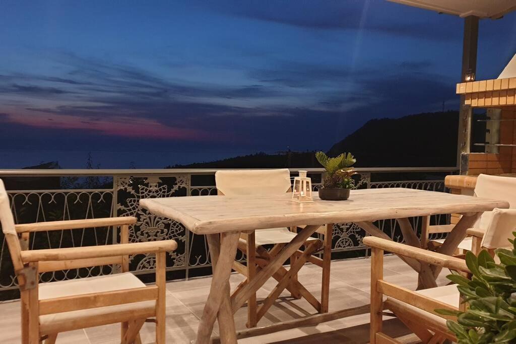 a wooden table and chairs on a balcony at Pure Blue House in Athanion