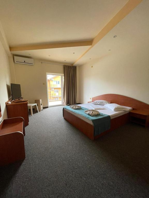 a bedroom with a bed and a desk and a window at Vila Senator 1 in Eforie Nord