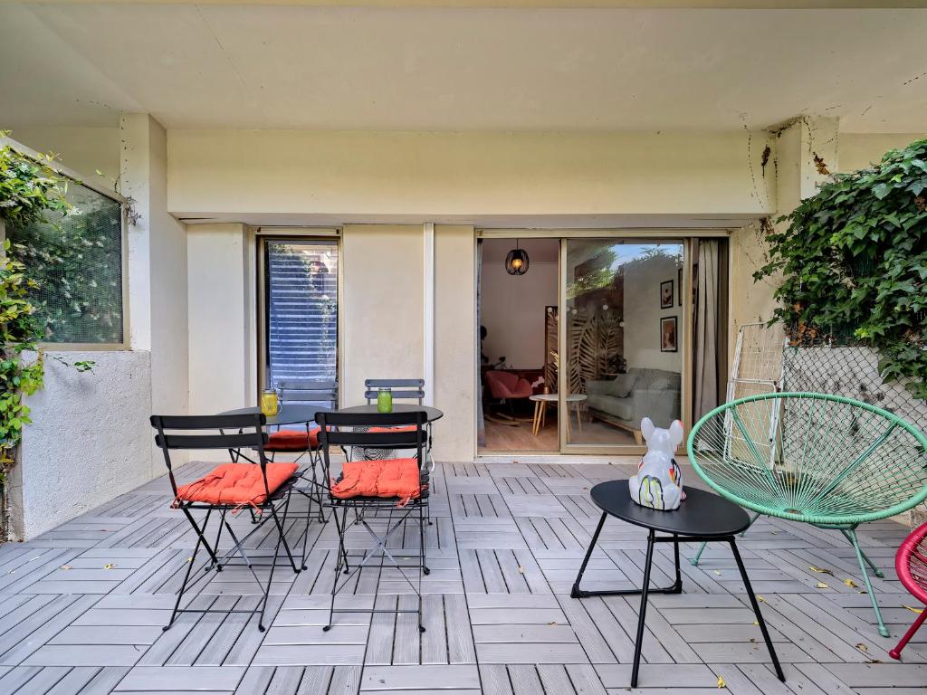 d'une terrasse avec des chaises, des tables et une table. dans l'établissement Studio cosy à 30 mètres de la plage, à Antibes