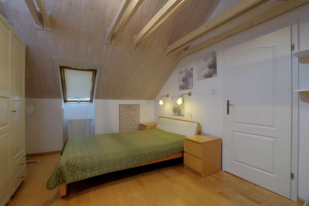 una camera con letto verde e soffitto in legno di Two-level apartament + garden. Dwupoziomowe mieszkanie + ogród a Gdynia