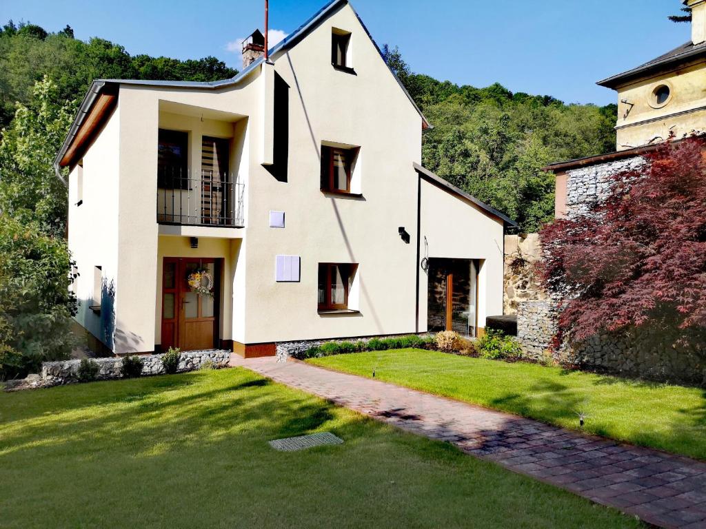 una casa blanca con un patio verde en Prázdninový dům Valdík, en Loket