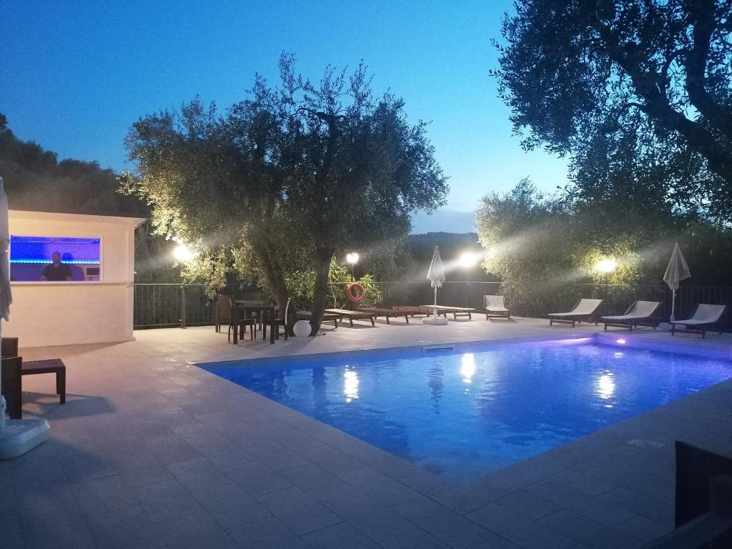 - une piscine de nuit avec des tables et des chaises dans l'établissement Agriturismo Valle Dei Gelsi, à Peschici