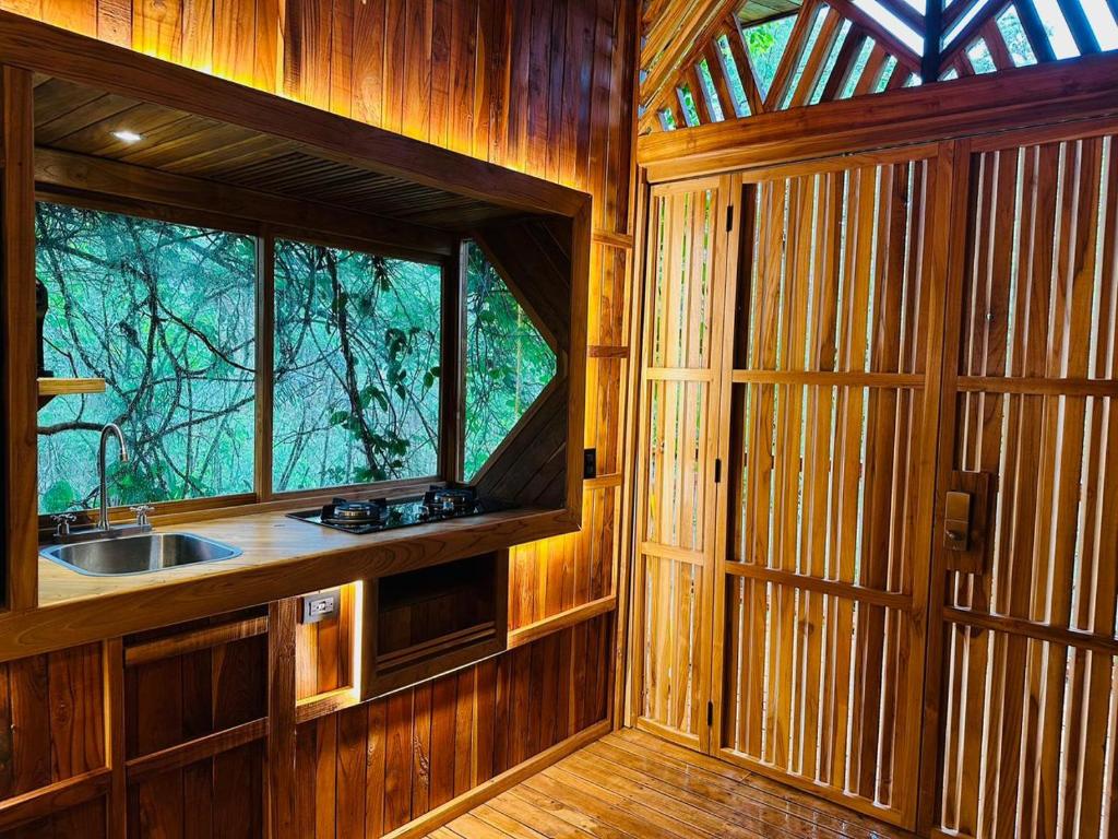 een keuken met een wastafel en een raam in een kamer bij Tamarindo Pura Selva Eco Tree House in Guatemala