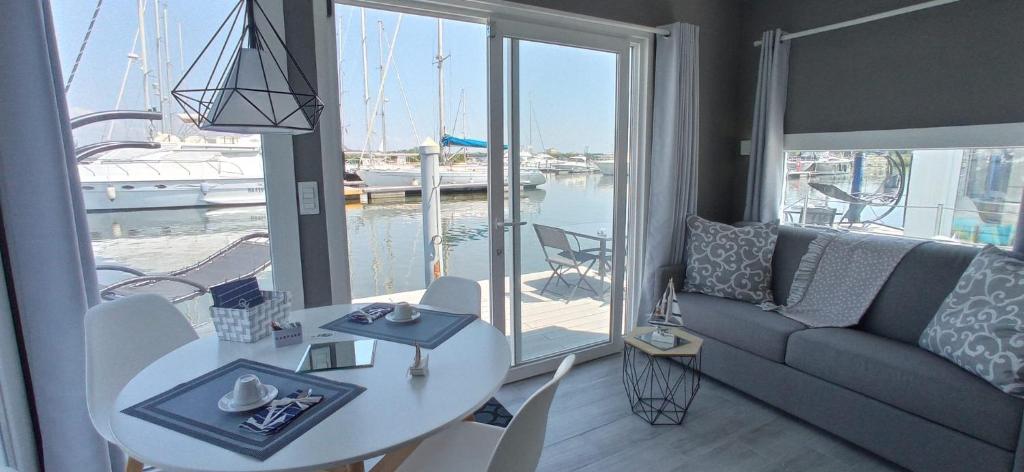 een woonkamer met een bank, een tafel en een raam bij Marina degli Estensi Floating Resort in Lido degli Estensi