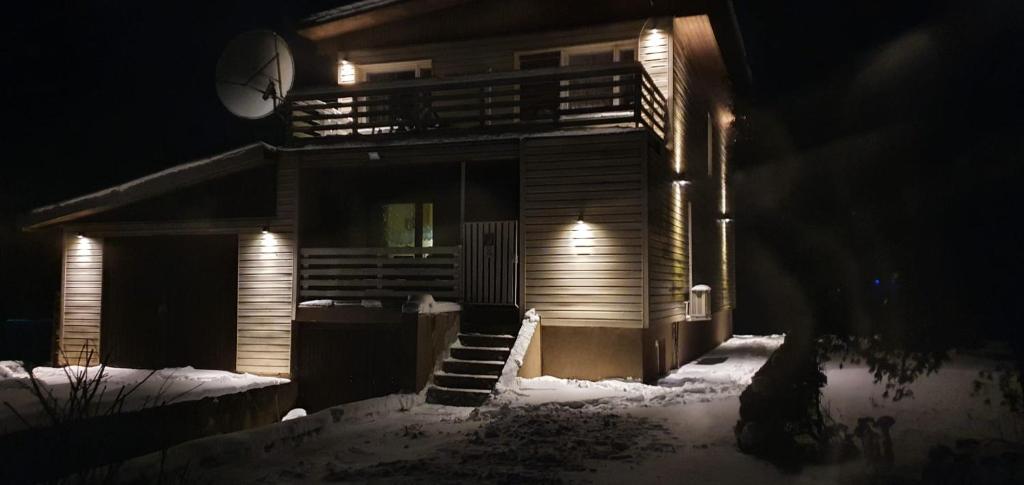 una casa de noche con nieve delante en Jaama Puhkemaja en Puka