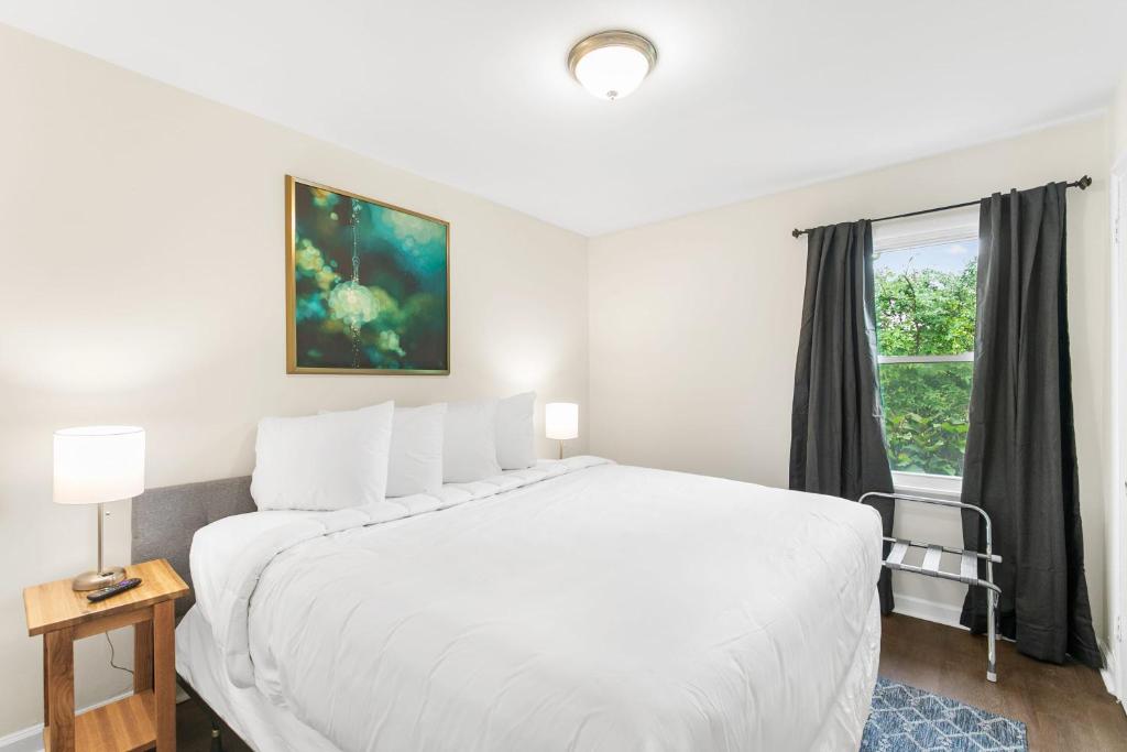 a white bedroom with a large white bed and a window at The Bricks - Apt 7 in Birmingham