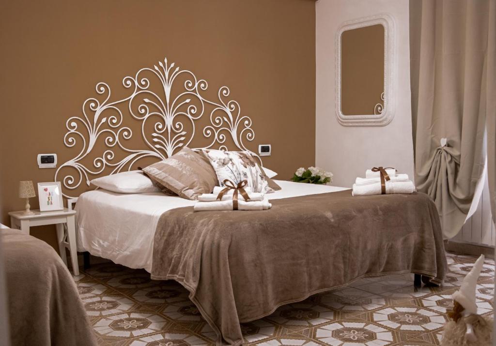 Mausida Guest House في ليدو دي أوستيا: غرفة نوم بسرير كبير عليها مناشف