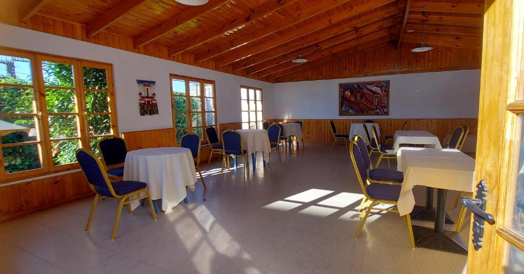 uma sala de jantar com mesas, cadeiras e janelas em Hotel Chagual em La Serena