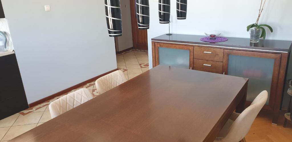 プルシュチ・グダンスキにあるKaja Apartament 52m2の木製テーブルと椅子付きのキッチン
