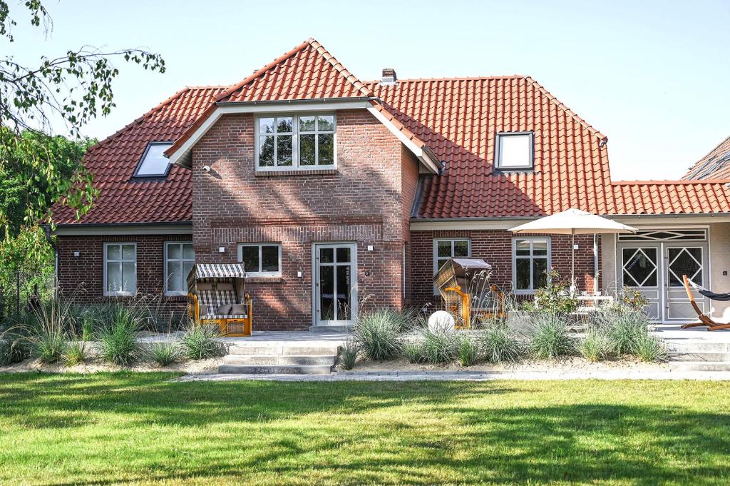 a brick house with a lawn in front of it at Bi de Bark in Fehmarn