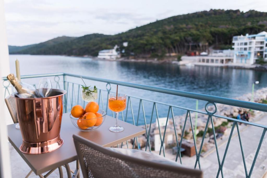 a table with oranges on a balcony with a view of the water at Propela apartments in Božava