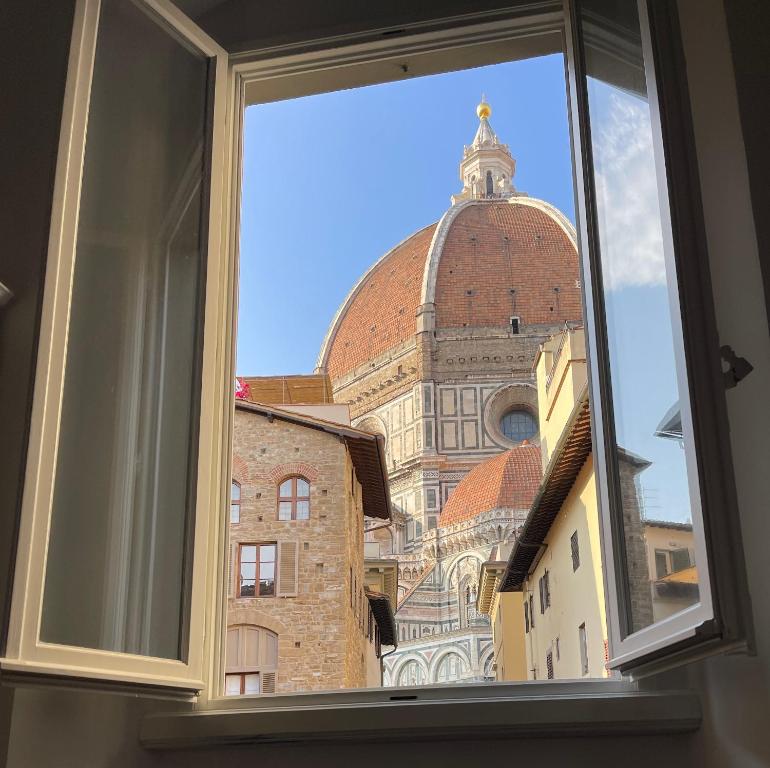 een raam met uitzicht op een gebouw bij Casa Orsi - appartamento fronte Duomo a Firenze in Florence