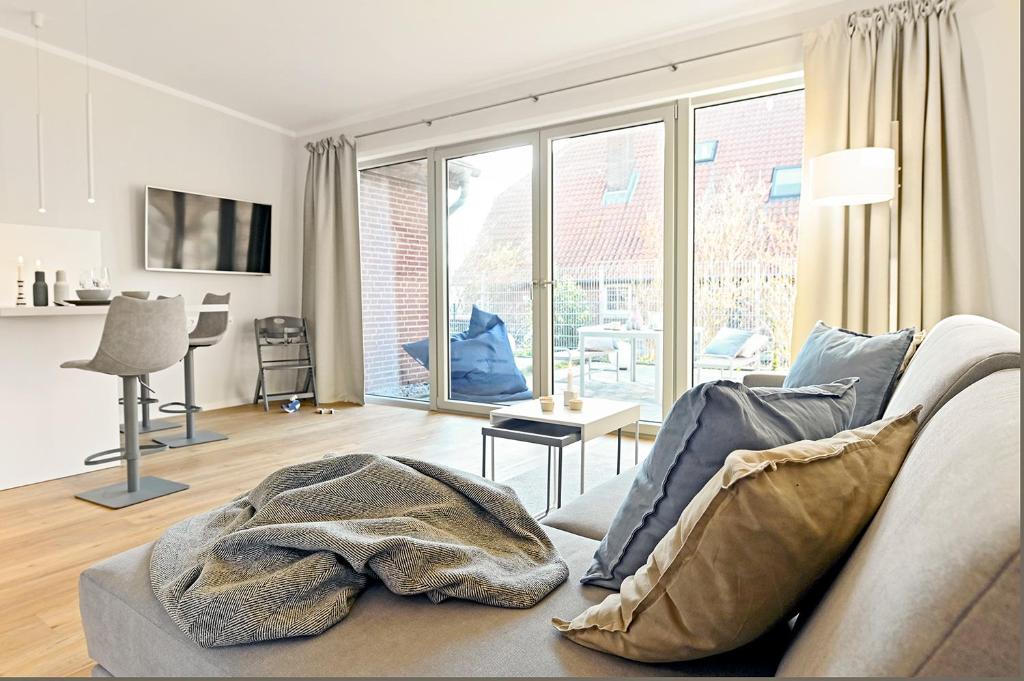 ein Wohnzimmer mit einem Sofa und einem großen Fenster in der Unterkunft Op de Düün in Fehmarn