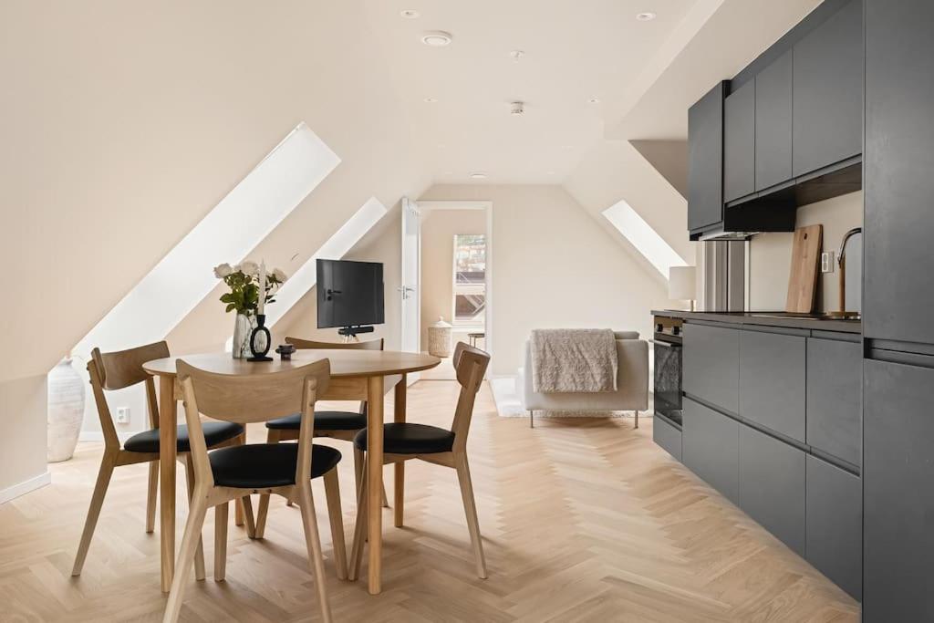 a kitchen and dining room with a table and chairs at Dinbnb Apartments I Mid-City Luxury with Mini Balcony and Smart TV & Sound System in Bergen