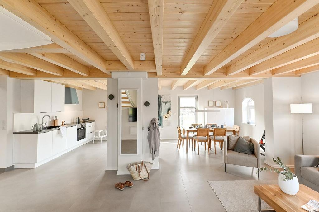 a kitchen and living room with a wooden ceiling at Kleene Slott in Fehmarn