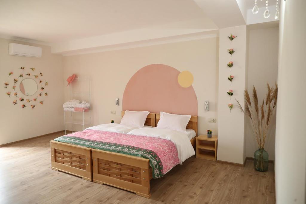 a bedroom with a large bed with a pink headboard at hOlarooms N1 in Sachure