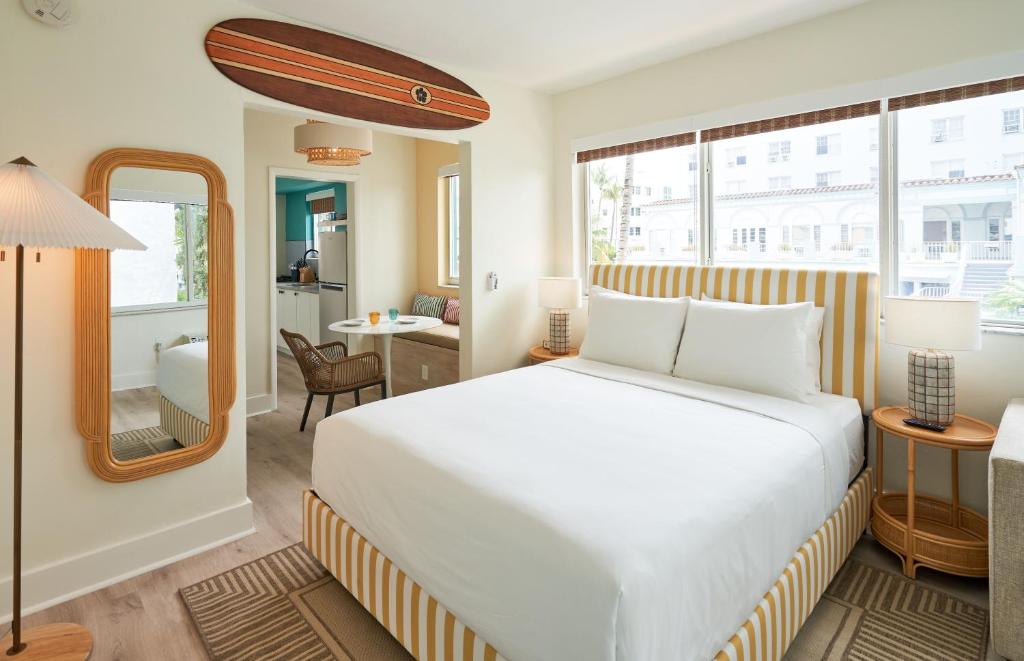 1 dormitorio con cama blanca y espejo en Aloha Fridays, en Miami Beach