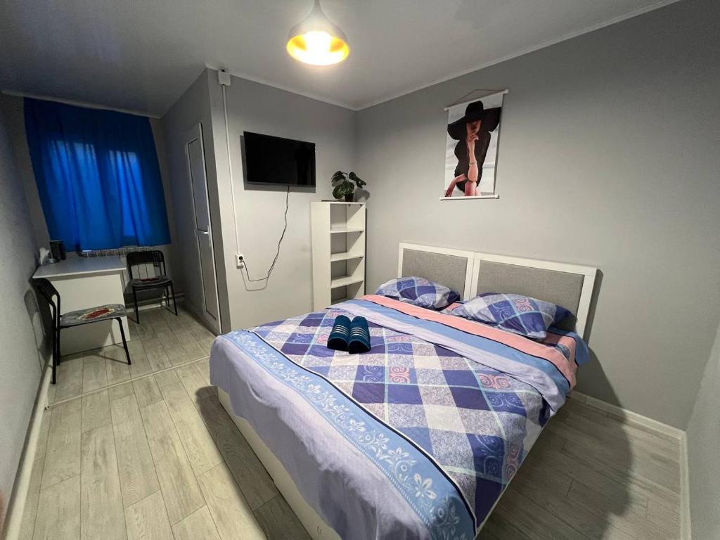 a bedroom with a bed and a desk and a television at Day and Night II in Tokolʼdosh