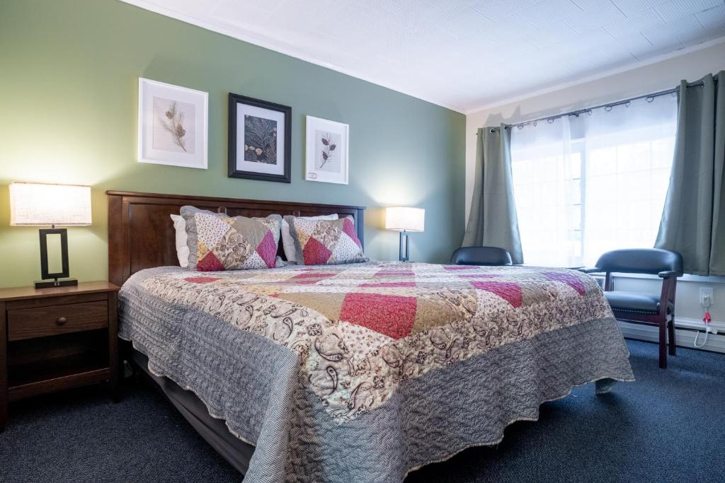 1 dormitorio con 1 cama, 2 lámparas y ventana en Acadia Pines Motel, en Bar Harbor