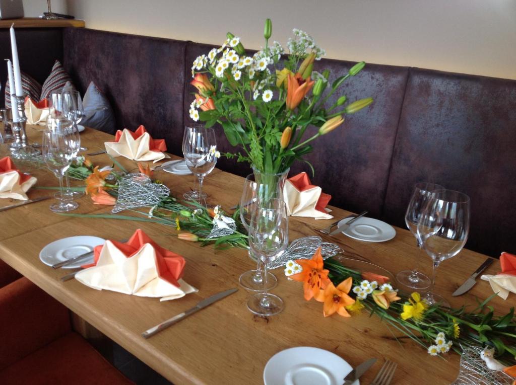 a wooden table with a vase of flowers on it at Der Winklhof in Saalfelden am Steinernen Meer