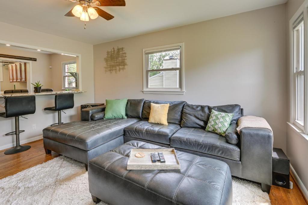 a living room with a leather couch and a table at Greensboro Vacation Rental 2 Mi to Downtown! in Greensboro