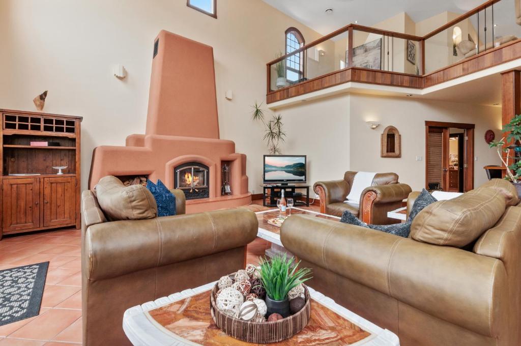 a living room with couches and a fireplace at Casa Grande Inn & Suites in Penticton