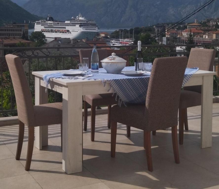 a table and chairs with a cruise ship in the background at Guesthouse Nikoleta 2 in Kotor
